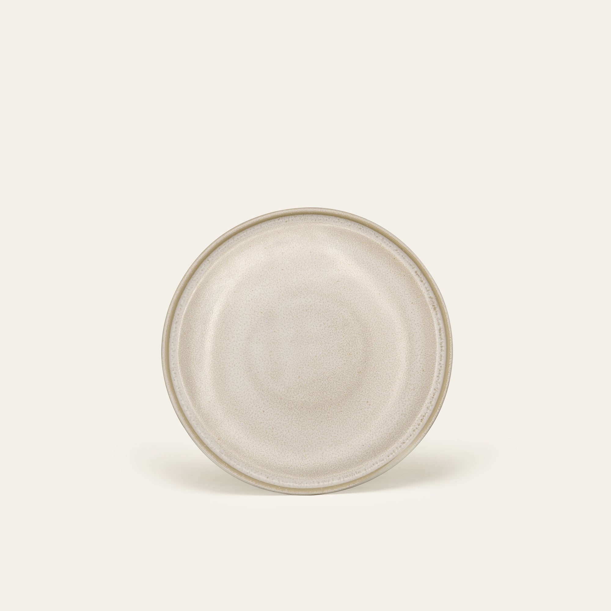 Runder Steingut Teller in Beige.