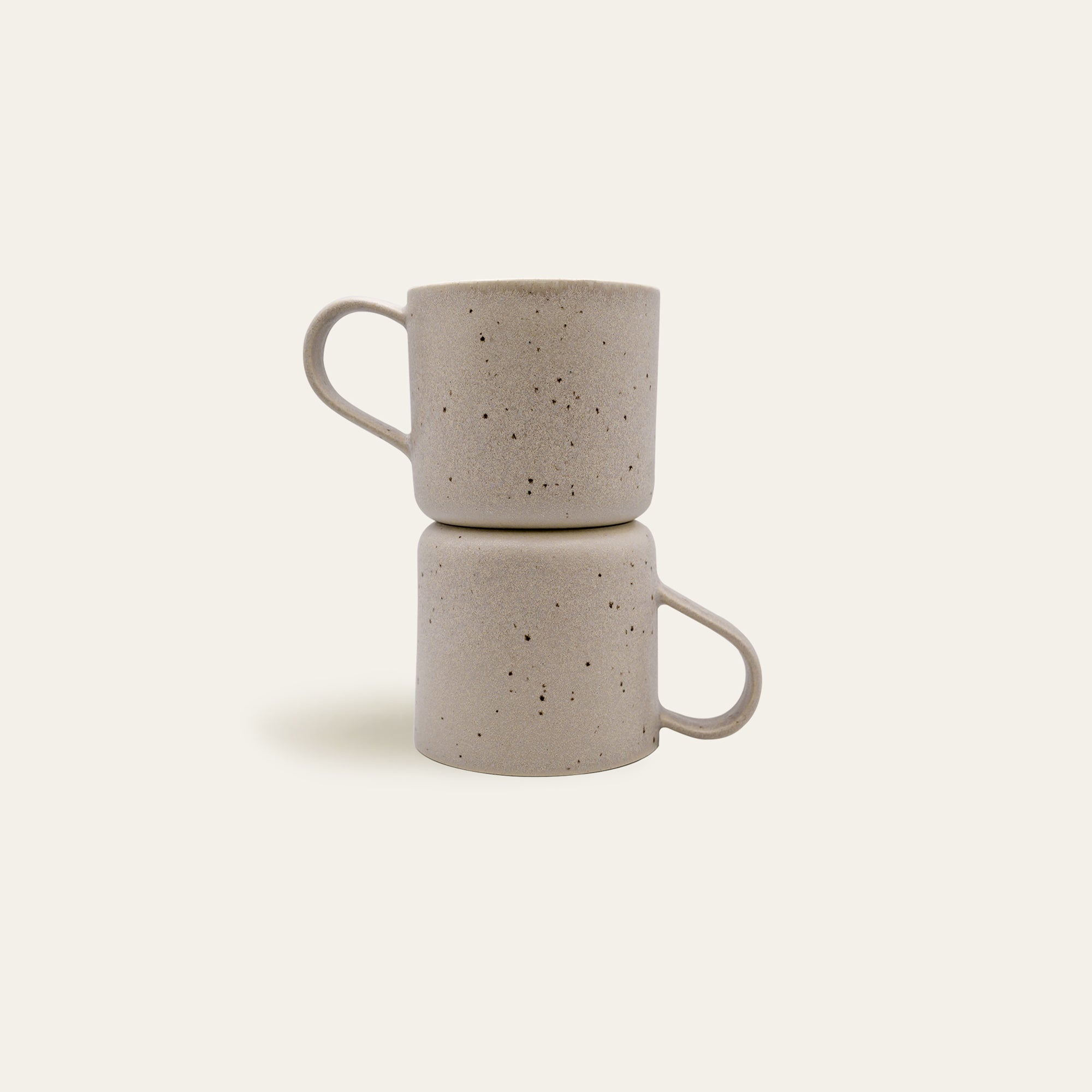 Zwei aufgestellte Steingut Tassen in Beige.