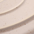 Detail von Steingut Teller in Beige.