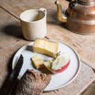 Steingut Teller in Beige, belegt mit Käse, Apfel und Brot.